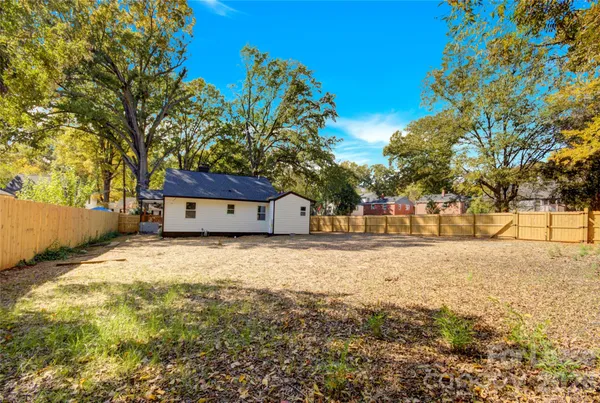 a tall house with large trees in front of it