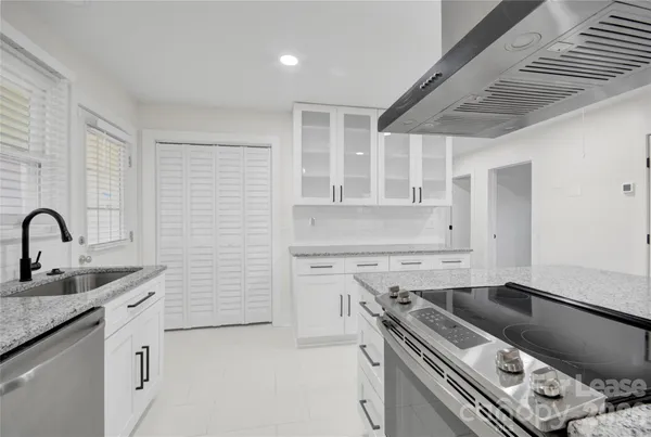 a kitchen with granite countertop a sink stainless steel appliances and cabinets