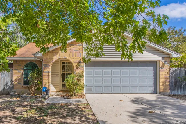 a front view of a house with a tree