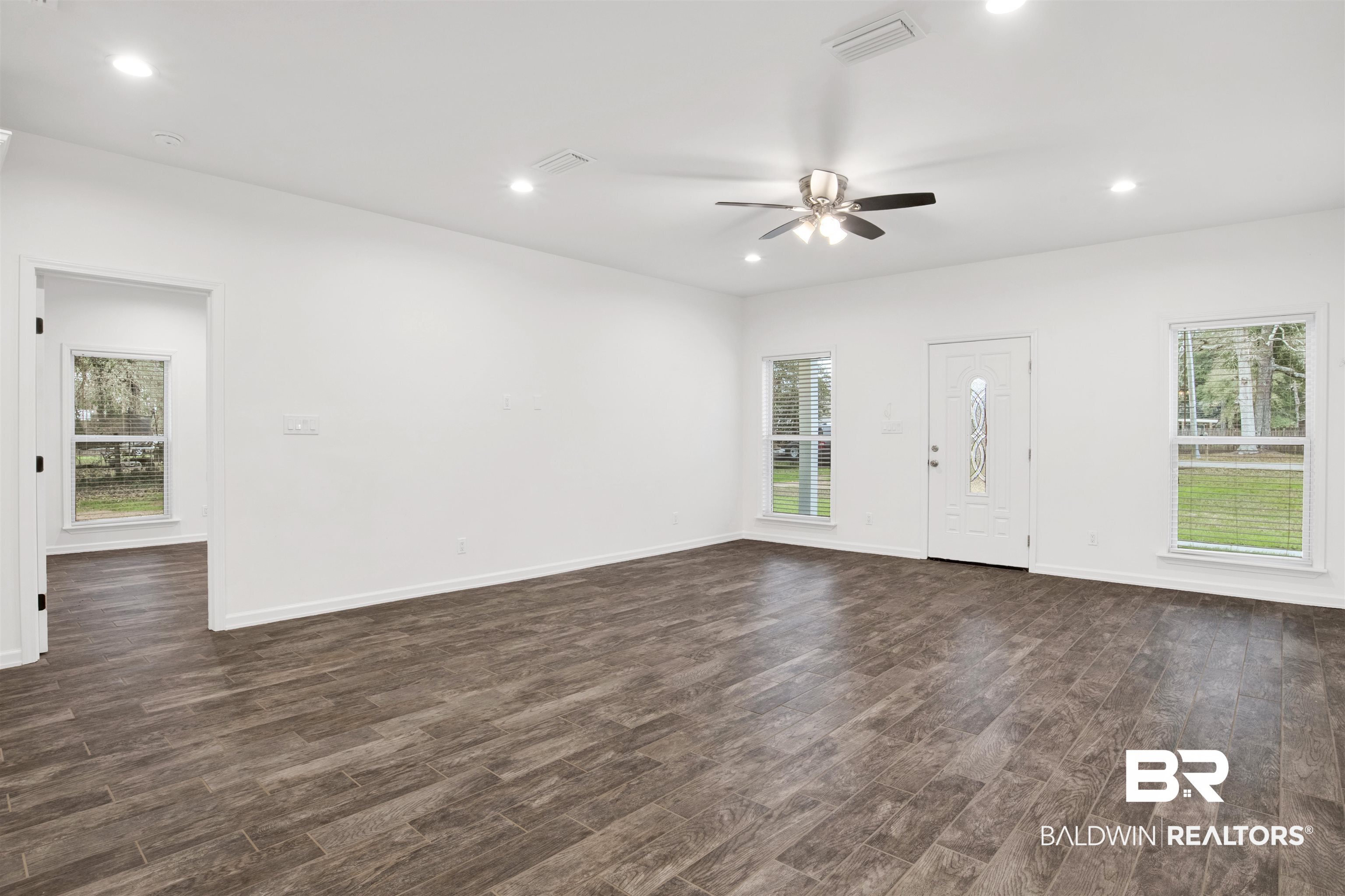 10871 Somerset Road Grand Bay, AL 36541 - Photo 17 of 31 Unfurnished living room with a healthy amount of sunlight, dark hardwood / wood-style flooring, and ceiling fan