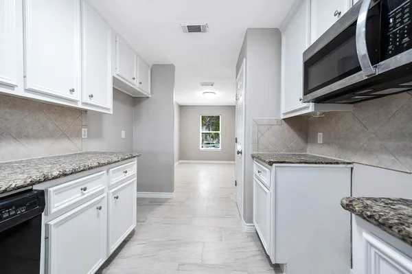 a kitchen with stainless steel appliances granite countertop a stove and a microwave