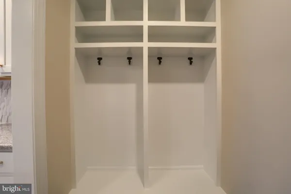 an empty room with wooden floor fireplace and windows