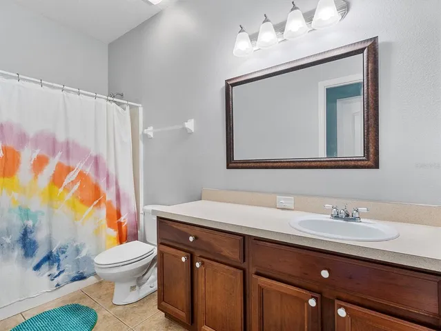 a bathroom with a sink vanity mirror and toilet