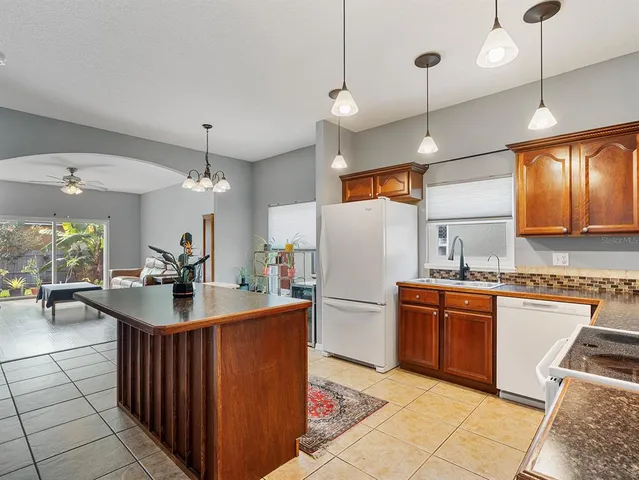 a kitchen with stainless steel appliances granite countertop a sink a stove and a refrigerator