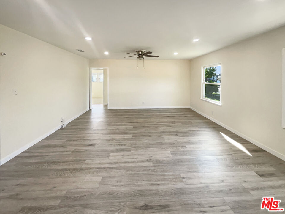 13242 Cornuta Avenue Downey, CA 90242 - Photo 3 of 19 an empty room with wooden floor ceiling fan and windows