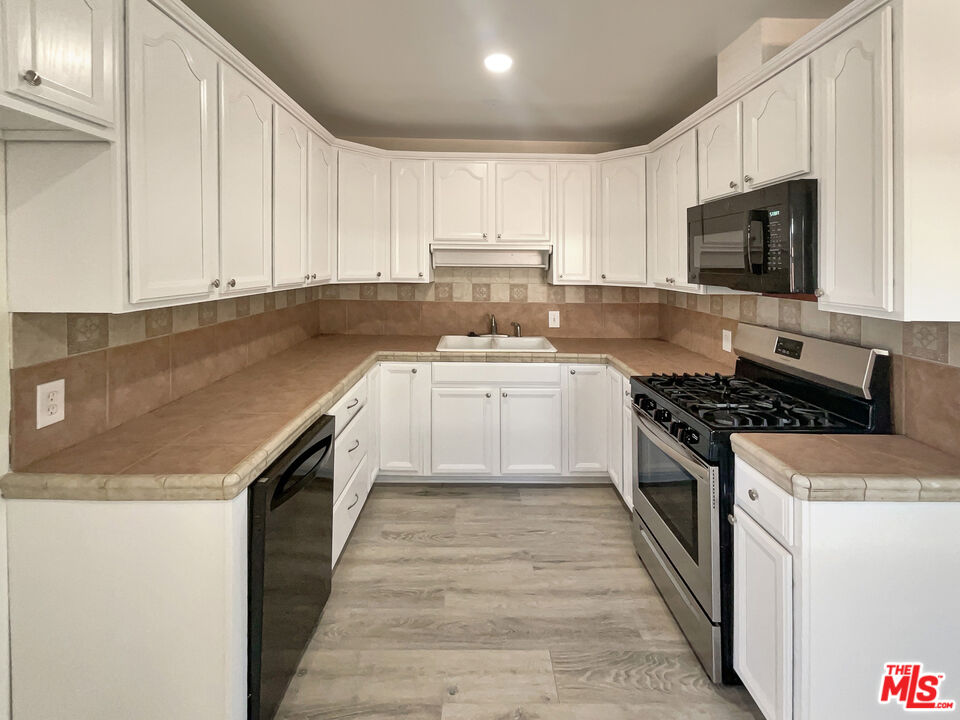 13242 Cornuta Avenue Downey, CA 90242 - Photo 7 of 19 a kitchen with a sink stove top oven and cabinets