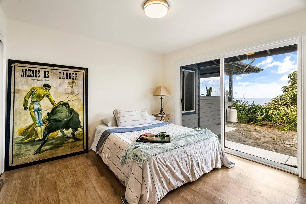 89-857 Hawaiʻi Belt Road Captain Cook, HI 96704 - Photo 18 of 30 a bedroom with a bed and a painting on the wall