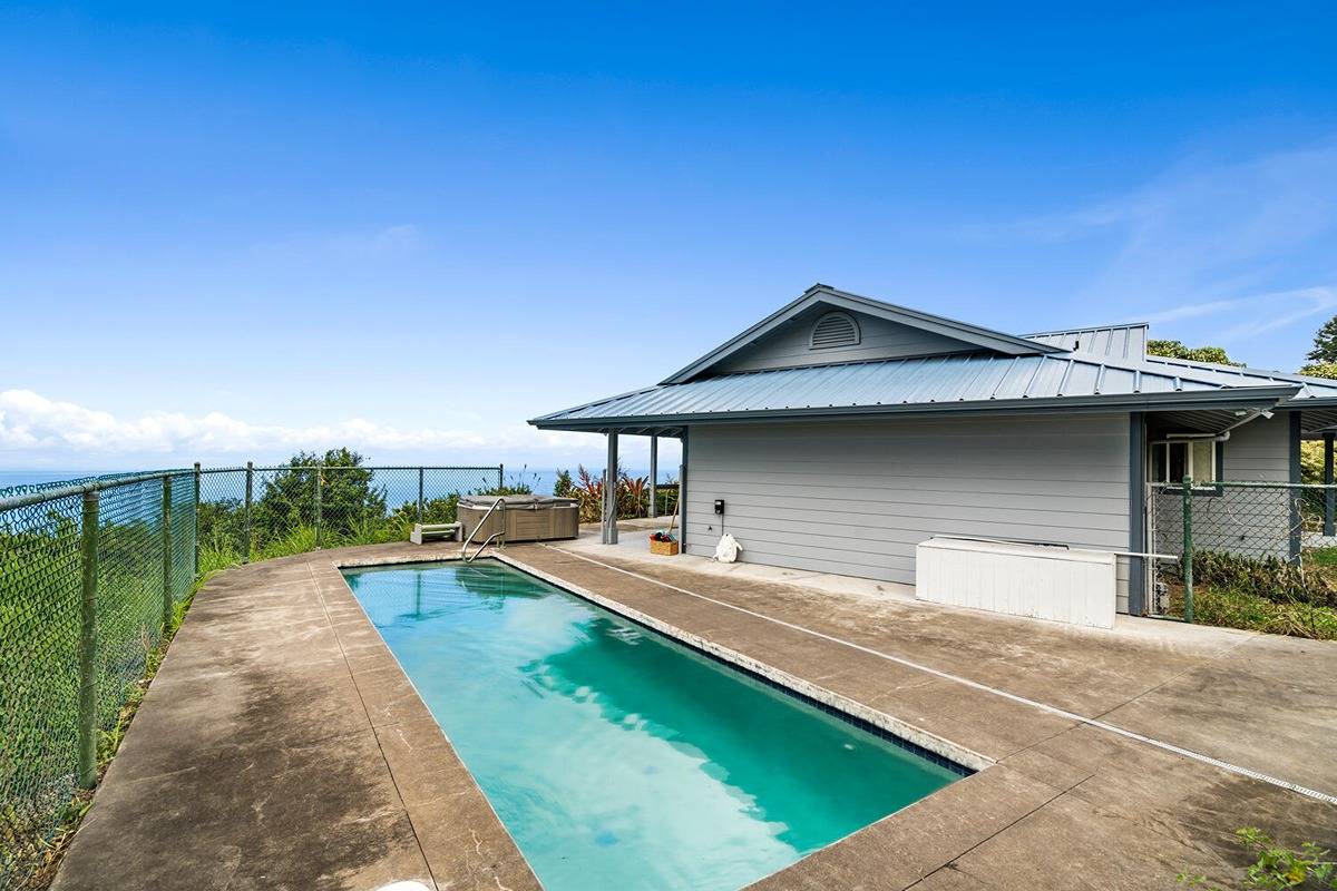 89-857 Hawaiʻi Belt Road Captain Cook, HI 96704 - Photo 5 of 30 a house with swimming pool in front of it