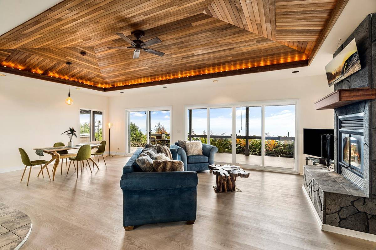 89-857 Hawaiʻi Belt Road Captain Cook, HI 96704 - Photo 6 of 30 a living room with fireplace furniture and a rug