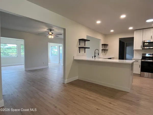 a kitchen with stainless steel appliances granite countertop a sink window and cabinets