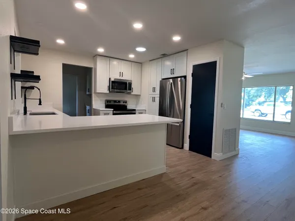 a kitchen with stainless steel appliances a refrigerator and a stove top oven