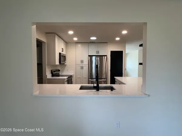 a view of kitchen with refrigerator and window