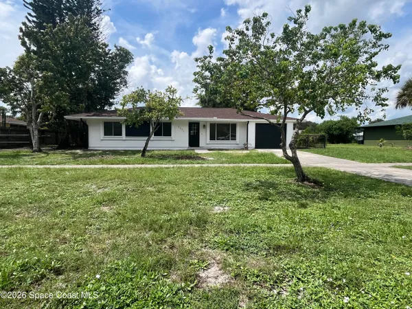 a house with green field in front of it