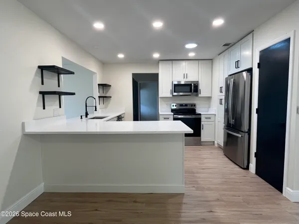 a kitchen with refrigerator and a sink