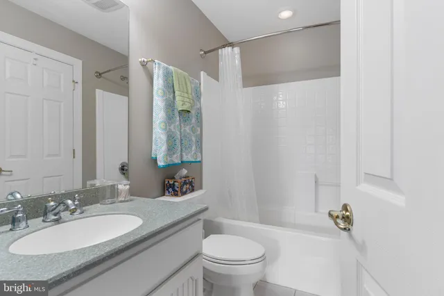 a view of a dining room with furniture a chandelier and large windows
