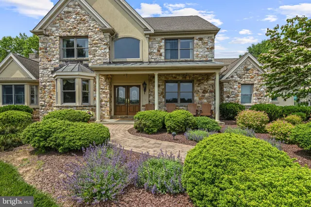 an aerial view of a golf course with huge green field and large trees