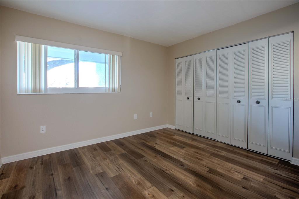 3300 South Beneva Road, Unit 214 Sarasota, FL 34232 - Photo 13 of 22 a view of an empty room with wooden floor and a window
