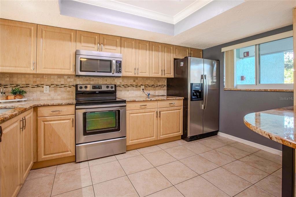 3300 South Beneva Road, Unit 214 Sarasota, FL 34232 - Photo 2 of 22 a kitchen with stainless steel appliances granite countertop a stove a sink and a refrigerator