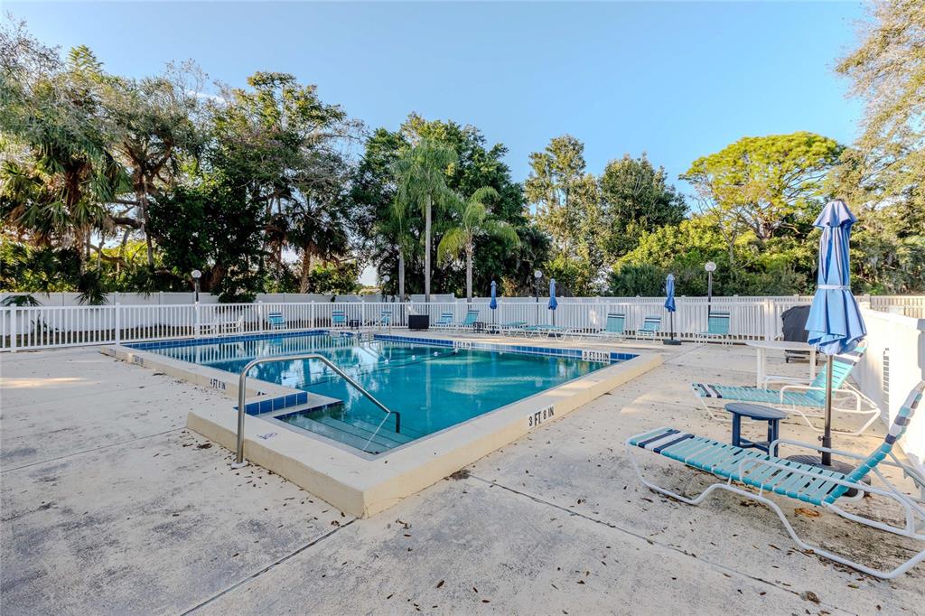 3300 South Beneva Road, Unit 214 Sarasota, FL 34232 - Photo 21 of 22 a view of a swimming pool with a patio and a yard