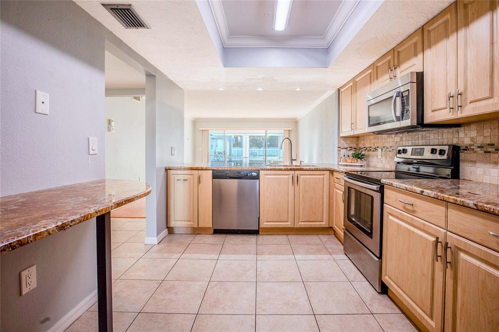 3300 South Beneva Road, Unit 214 Sarasota, FL 34232 - Photo 3 of 22 a kitchen with stainless steel appliances granite countertop a stove a sink and a microwave