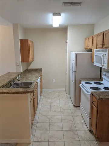 a kitchen with stainless steel appliances granite countertop a stove a refrigerator and a sink