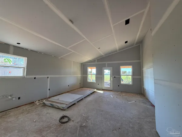 a large kitchen with stainless steel appliances granite countertop a stove a sink a refrigerator and white cabinets with wooden floor