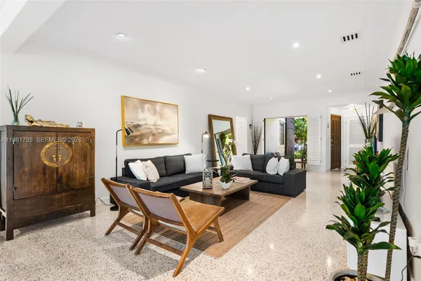 a living room with furniture and a potted plant