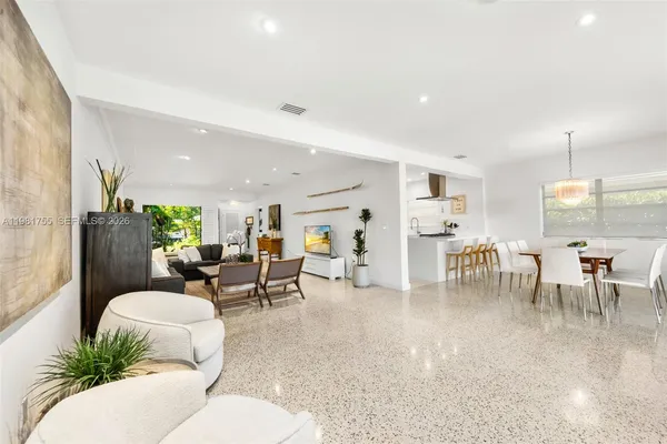 a living room with furniture and a dining table with chairs