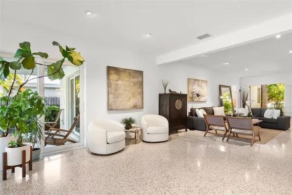 a view of a dining room and livingroom furniture wooden floor a rug and a chandelier