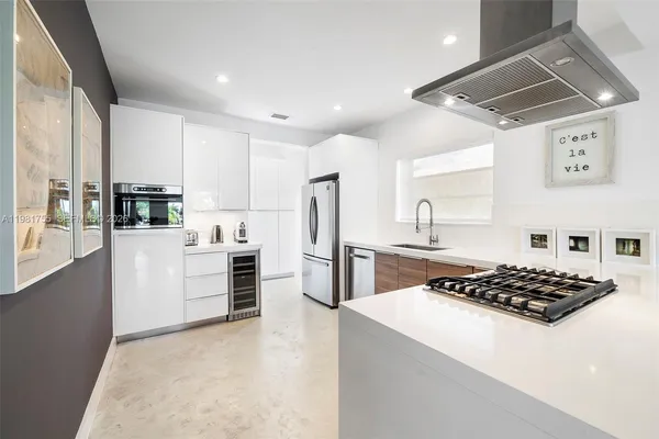 a kitchen with stainless steel appliances granite countertop a refrigerator a stove and a sink