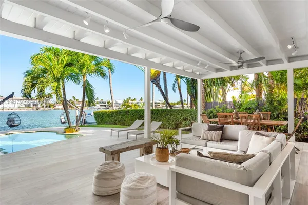 a living room with patio furniture and a floor to ceiling window