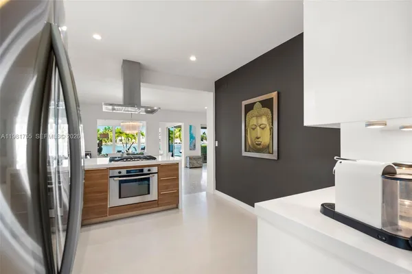a kitchen with stainless steel appliances granite countertop a stove a sink and a granite counter tops with white cabinets