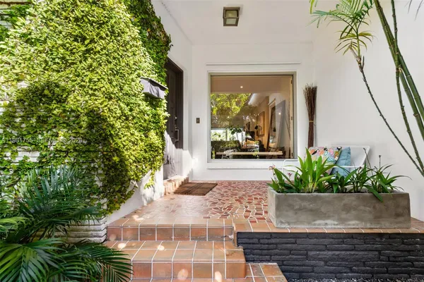 an aerial view of ocean and residential houses with outdoor space