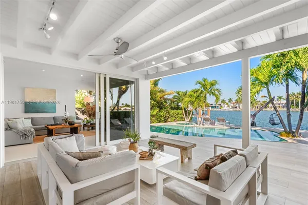 a living room with patio furniture and a floor to ceiling window