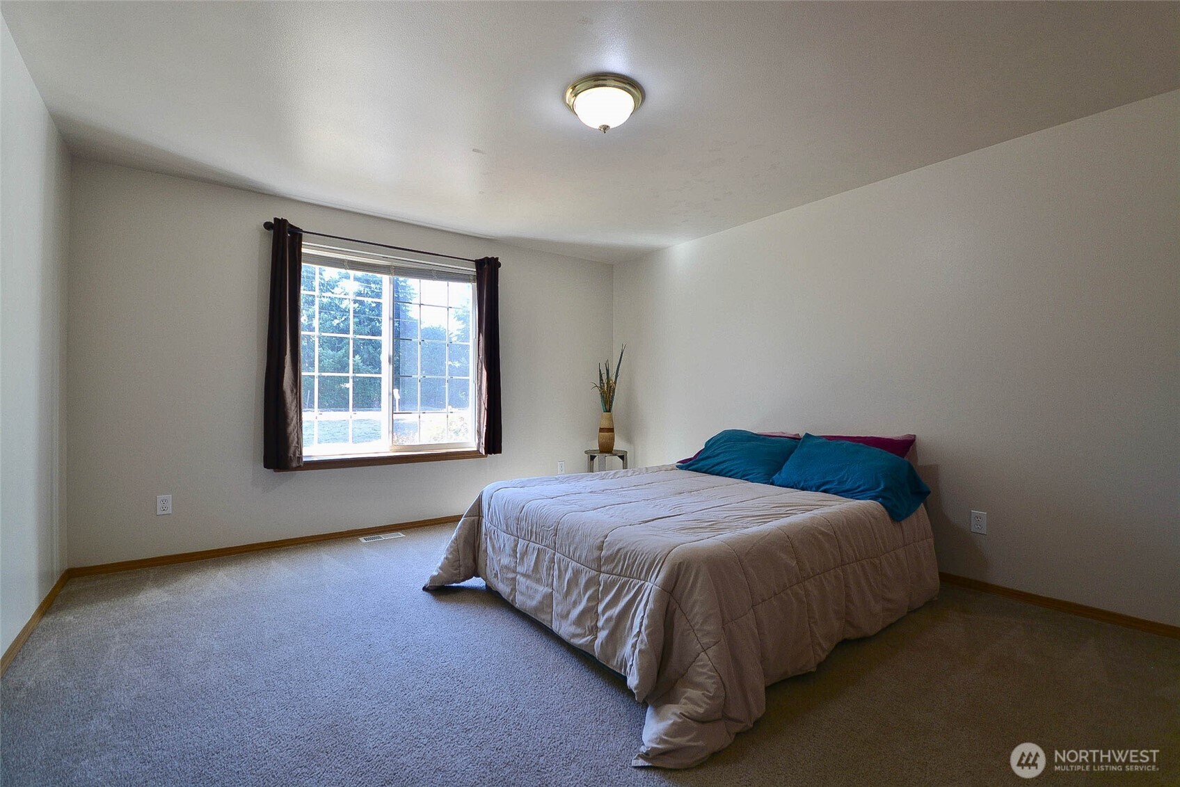 14638 Lawrence Lake Road Southeast Yelm, WA 98597 - Photo 16 of 38 a bed sitting in a bedroom next to a window
