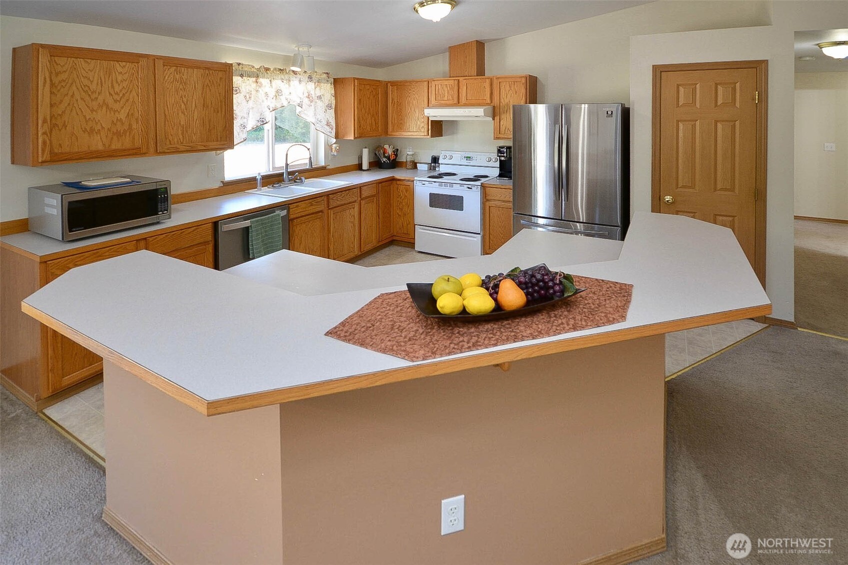14638 Lawrence Lake Road Southeast Yelm, WA 98597 - Photo 9 of 38 a kitchen with stainless steel appliances a stove refrigerator sink and a oven
