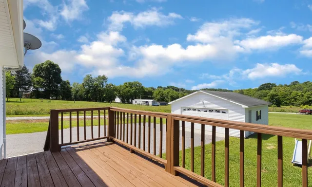a view of a balcony with wooden floor & fence