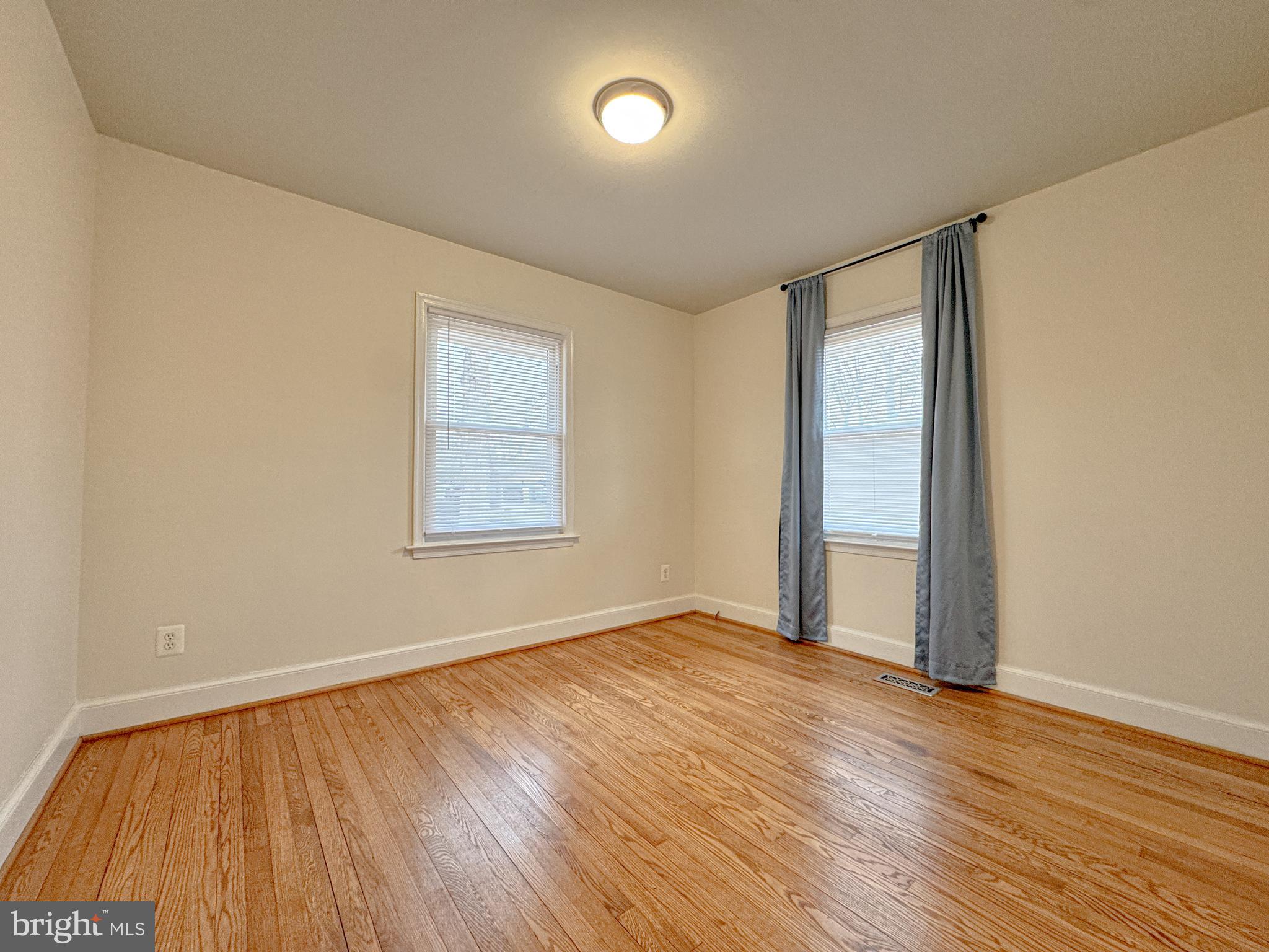 10 Blair Road Fredericksburg, VA 22405 - Photo 6 of 15 an empty room with wooden floor and windows