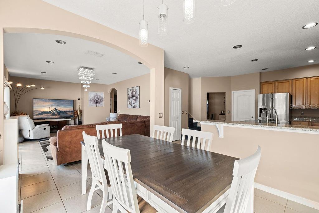 1349 Castleport Road Winter Garden, FL 34787 - Photo 18 of 40 a kitchen with stainless steel appliances granite countertop a stove top oven a sink a dining table and chairs with wooden floor