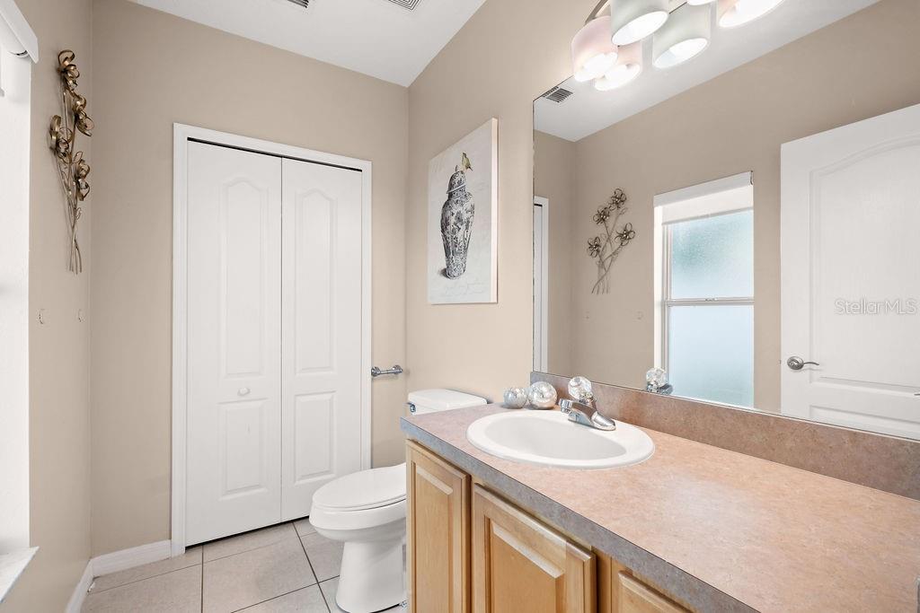 1349 Castleport Road Winter Garden, FL 34787 - Photo 20 of 40 a bathroom with a granite countertop sink a toilet and a mirror