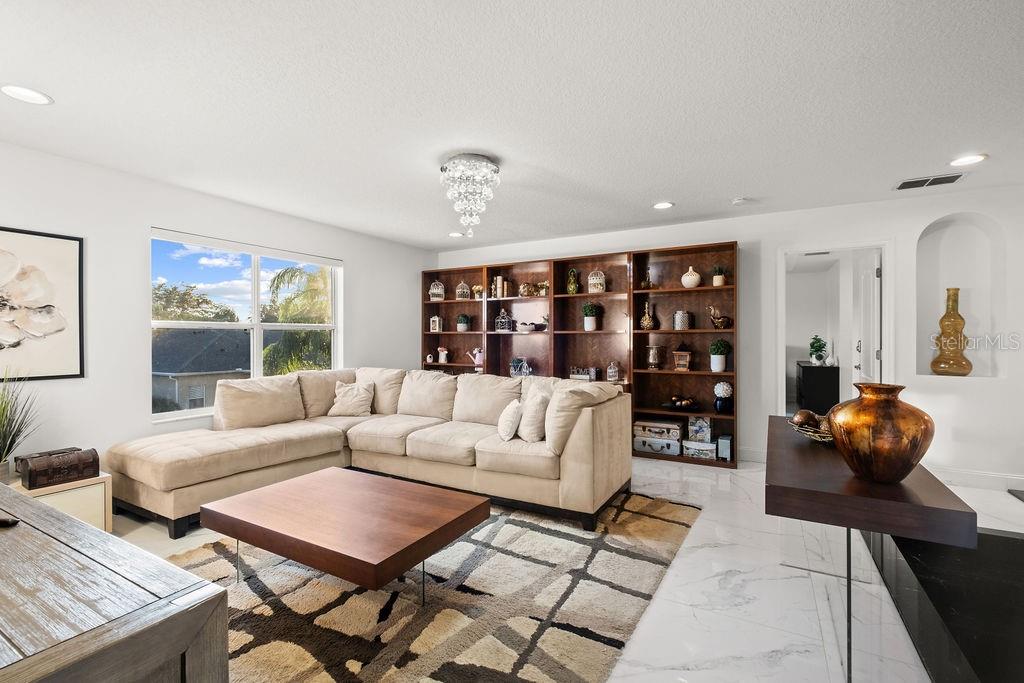 1349 Castleport Road Winter Garden, FL 34787 - Photo 23 of 40 a living room with furniture and a book shelf