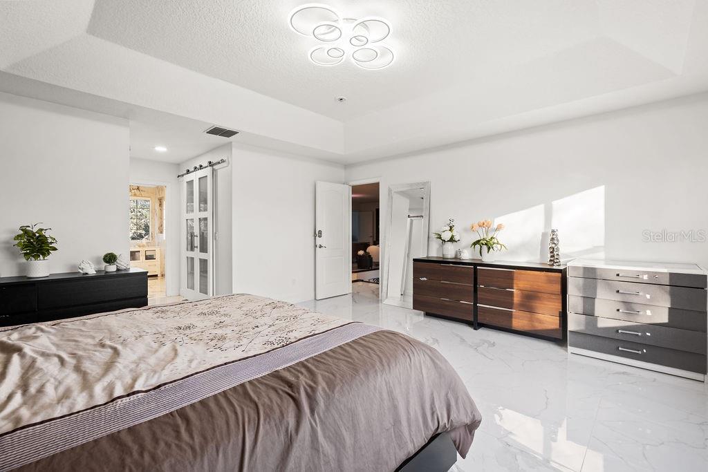 1349 Castleport Road Winter Garden, FL 34787 - Photo 28 of 40 a bedroom with a bed and dresser with mirror