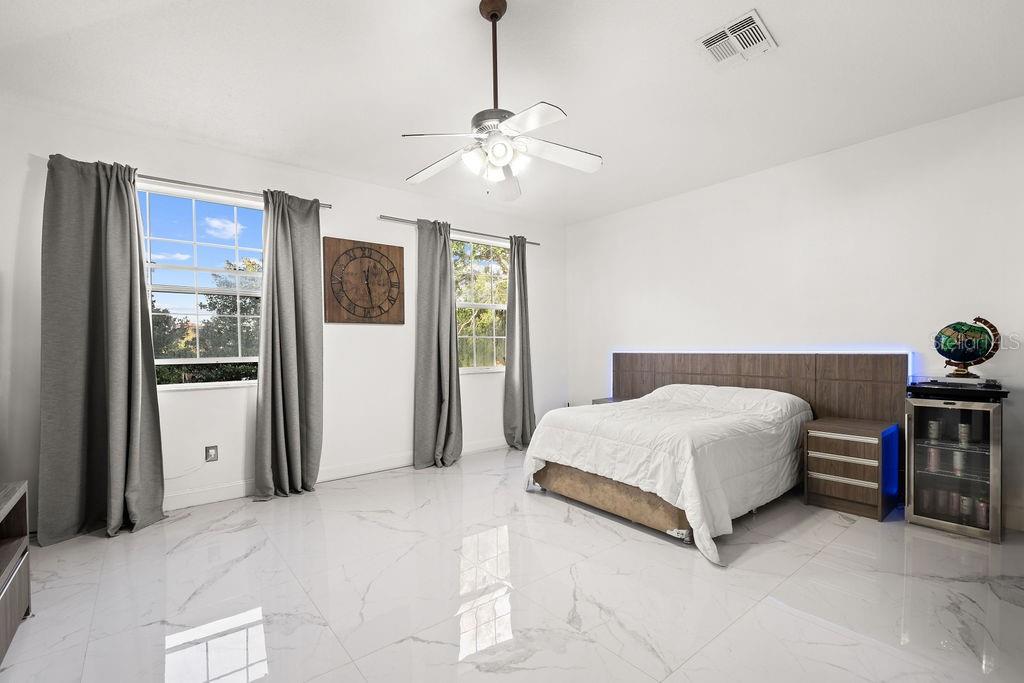 1349 Castleport Road Winter Garden, FL 34787 - Photo 34 of 40 a bedroom with a bed and a chandelier