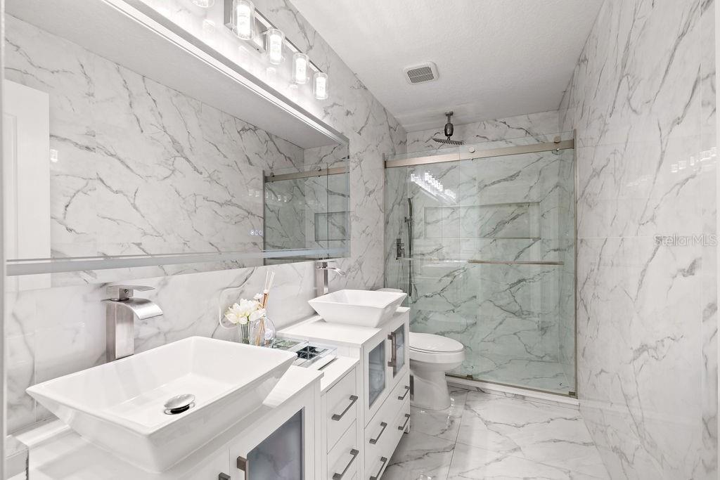 1349 Castleport Road Winter Garden, FL 34787 - Photo 36 of 40 a bathroom with a double vanity sink toilet and shower