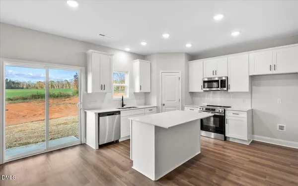 a kitchen with a sink stove top oven and refrigerator