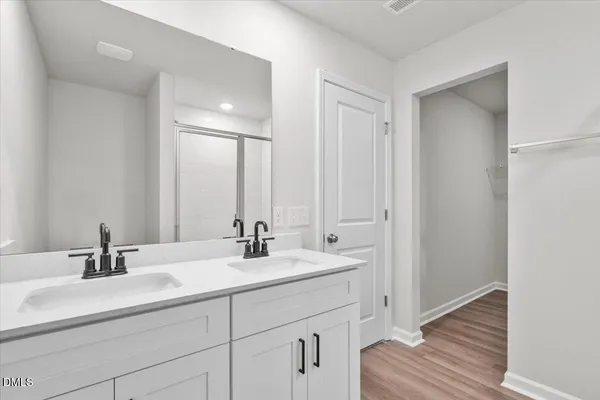 a bathroom with double vanity sink and a mirror
