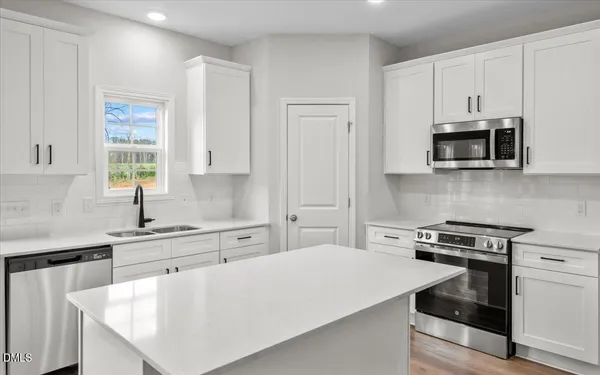 a kitchen with stainless steel appliances a stove microwave sink and cabinets