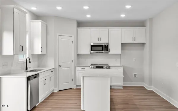 a kitchen with stainless steel appliances a sink stove and cabinets