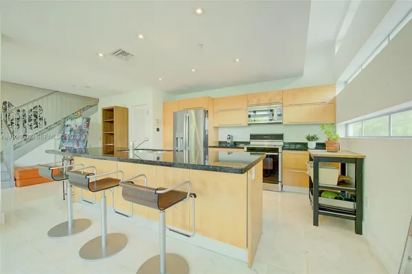 a kitchen with stainless steel appliances kitchen island granite countertop a sink and cabinets