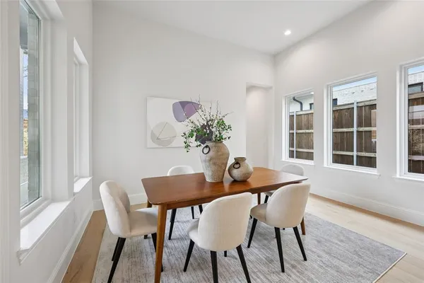 a dining room with furniture potted plants and wooden floor